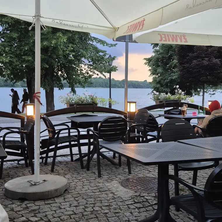 Taras restauracji z parasolami i widokiem na jezioro
